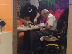 La foto virale: cassiere del fast food aiuta cliente disabile a tagliare il pranzo