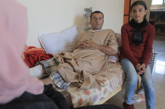 Reham accanto al padre colpito da un cecchino israeliano durante le proteste a Gaza (Ahmed Mashharawi/NRC)