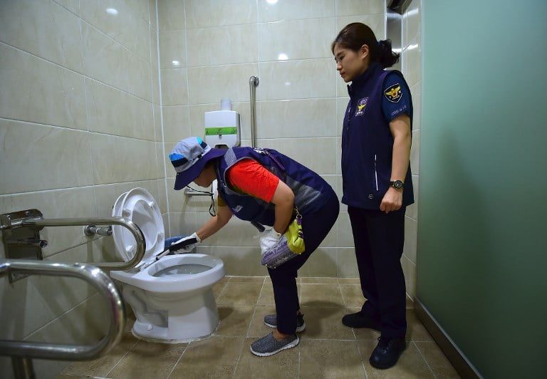 Agenti di polizia ispezionano un bagno pubblico a Seoul alla ricerca di telecamere nascoste (Gettyimages)