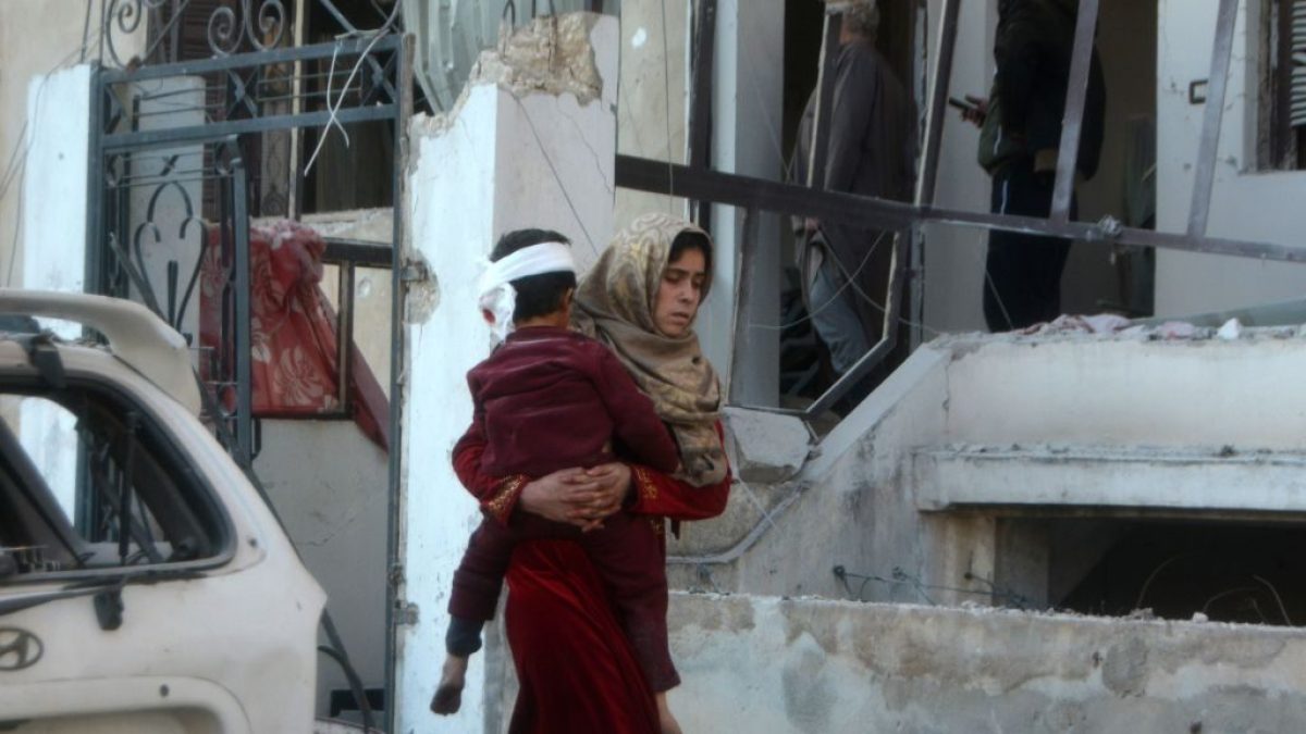 Una donna cerca di mettere in salvo il figlio dopo il bombardamento a Maarrat Misrin (Gettyimages)