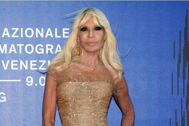 Piume e capelli al vento: Donatella Versace sfida così il maltempo a Venezia