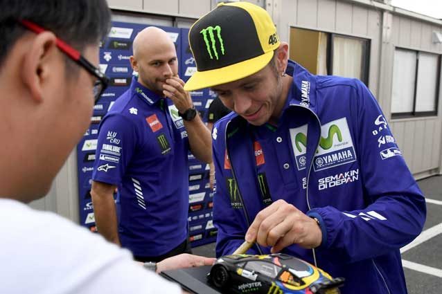 Valentino Rossi firma autografi nel paddock di Motegi / Getty Images