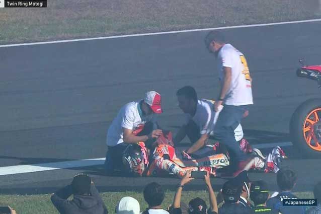 Marc Marquez a terra mentre il fratello Alex gli rimette la spalla in sede / MotoGP.com