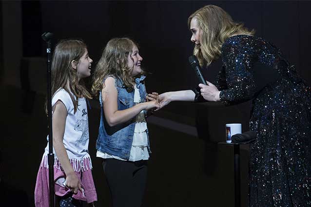 Adele con due piccole fan sul palco durante il concerto di Amsterdam (Getty Images)