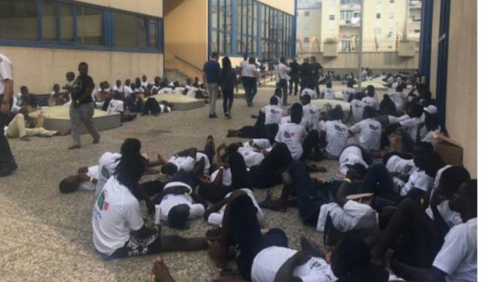 Alcuni dei 600 migranti con vestiti Armani negli hotel a cinque stelle a loro riservati