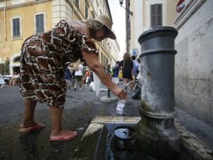 Una turista riempie una bottiglietta d'acqua in uno dei nasoni nel centro di Roma – Lapresse