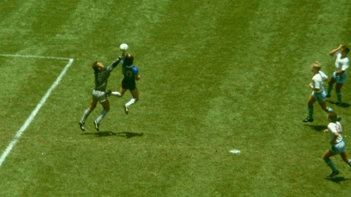 Il portiere dell’Inghilterra, Peter Shilton, viene beffato da Maradona che segna il gol con la mano de dios.