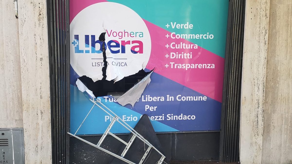 Una vetrata dell’ex sede elettorale di Voghera +Libera distrutta con un cartello stradale (foto da Facebook)