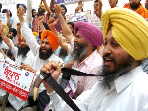 Una protesta di indiani sikh col pugnale sacro in primo piano (Archivio Getty images)