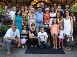 La famiglia Vallini: Augusto (camicia blu, in piedi) e Lucrecia (abito bianco, in piedi)