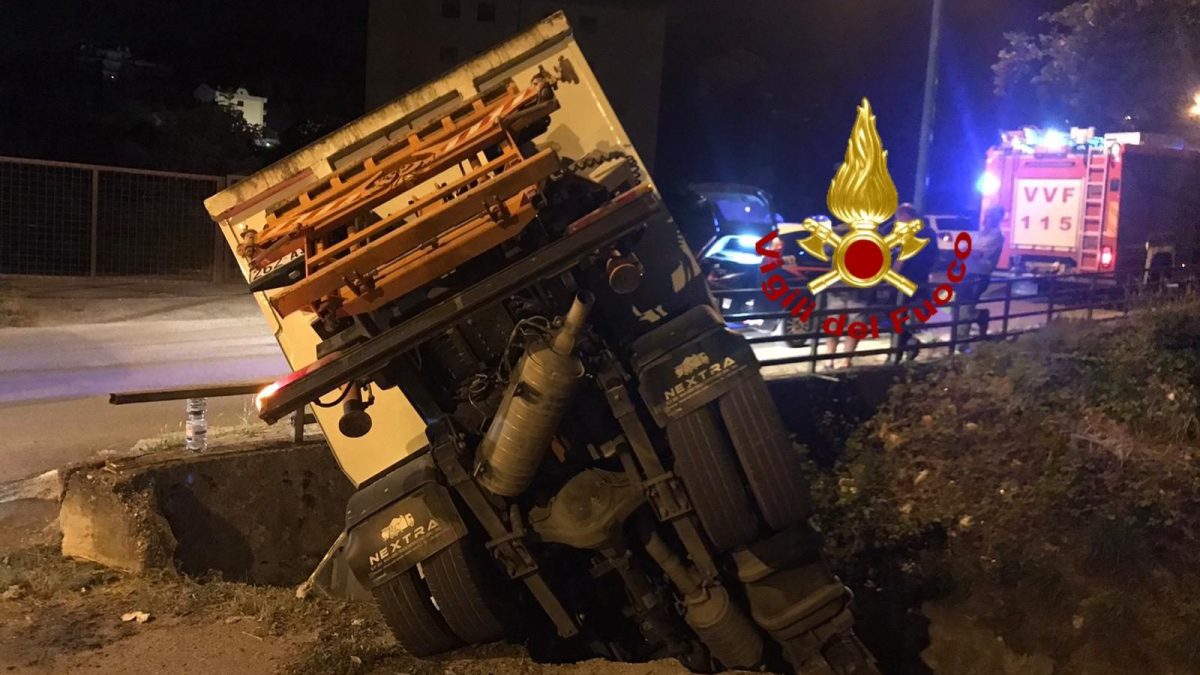 Il camion dei rifiuti finito nel torrente dopo aver sfondato un muretto.