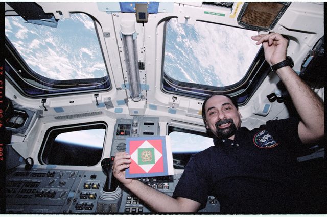 Umberto Guidoni con la bandiera della Presidenza della Repubblica italiana, a bordo dello Space Shuttle: credit Mariam10